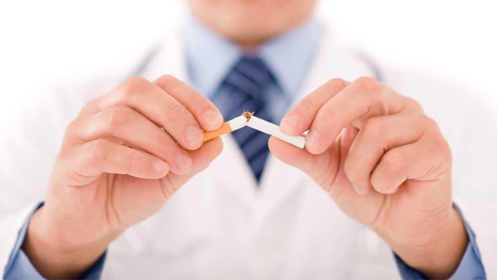Stop smoking mature doctor male breaks cigarette focus on hand