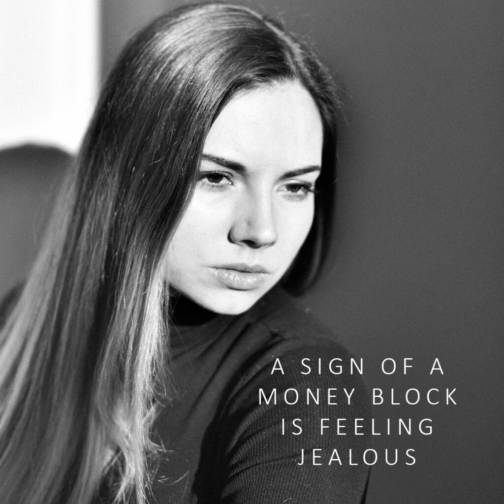 Unhappy woman with quote "A signs of a money block is feeling jealous."